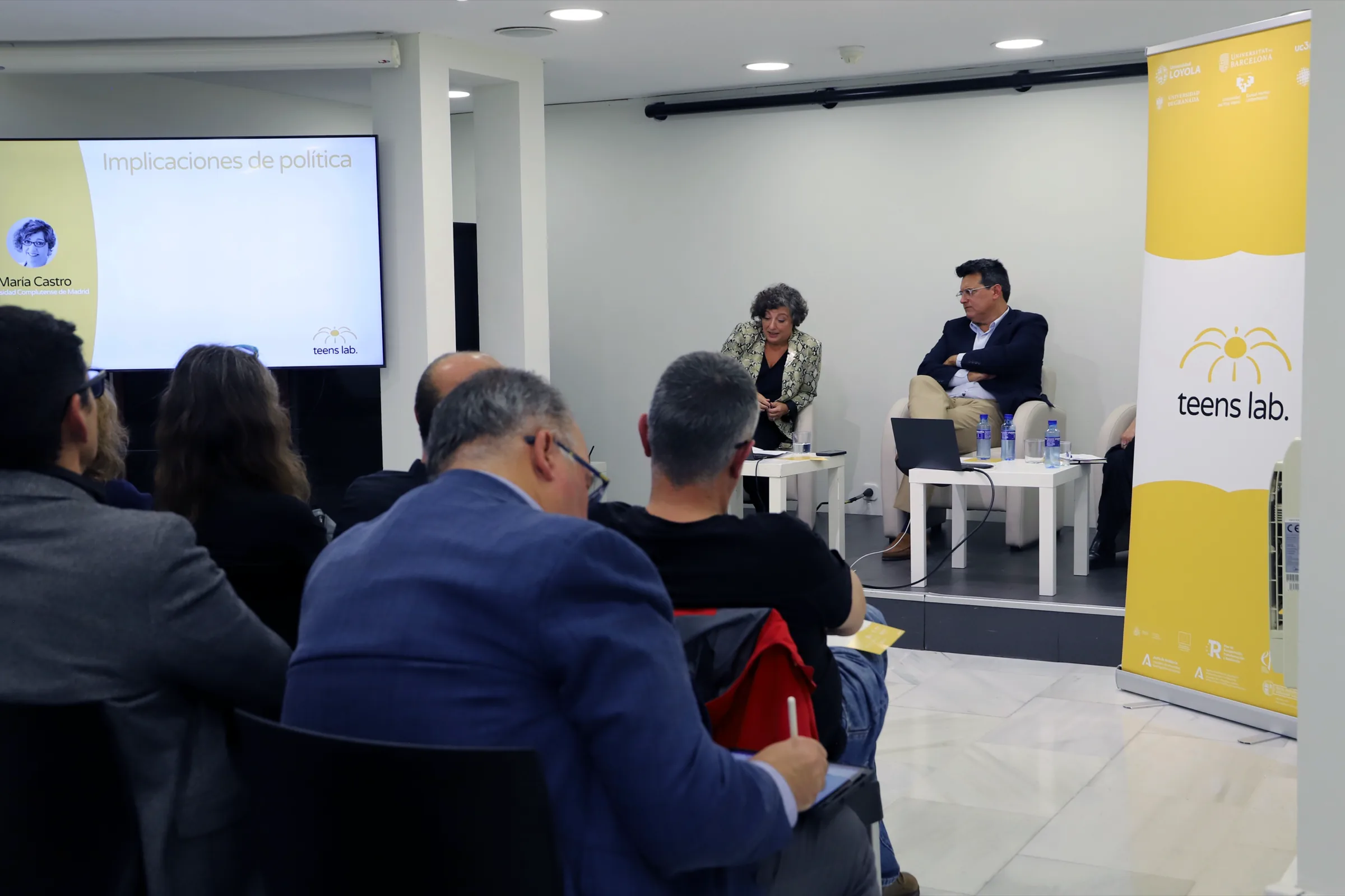 Panel discussion with the presentation on screen and the Teens Lab roll-up